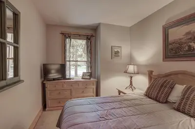 a bedroom with a bed and a tv and a window at 8757 Trappers Crossing Condo in Keystone