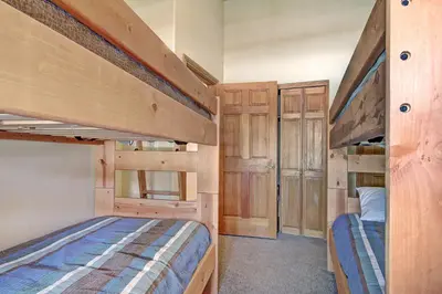 two bunk beds in a small room with wooden cabinets at 5983 Hidden River Lodge Condo in Keystone