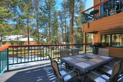 a patio with a table and chairs on a deck at 1633 Quicksilver Condo in Keystone