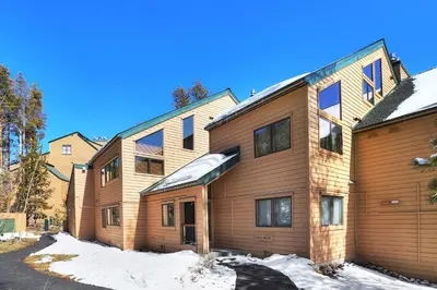 a large wooden building with snow on the ground at 1633 Quicksilver Condo in Keystone