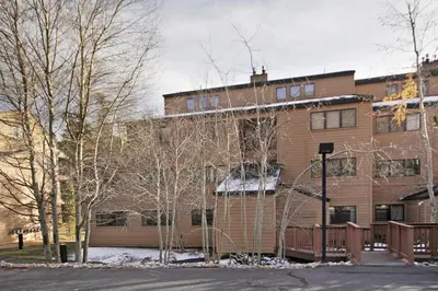 a brown brick building with trees in front of it at 1633 Quicksilver Condo in Keystone