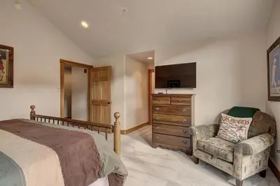 a bedroom with a bed and a chair and a dresser at 201 Mill Creek Condo in Keystone