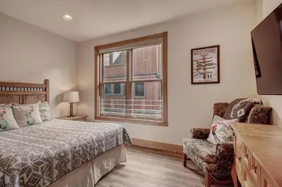 a bedroom with a bed and a chair and a window at 201 Mill Creek Condo in Keystone