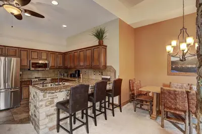 a kitchen with wooden cabinets and a table with chairs at 8912 The Springs Condo in Keystone