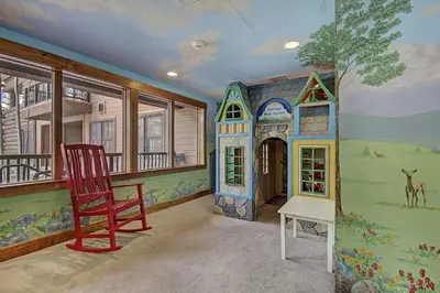 a room with a red chair and a play house at 8912 The Springs Condo in Keystone