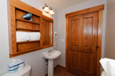 a bathroom with a sink and a wooden door at 8858 The Springs Condo in Keystone