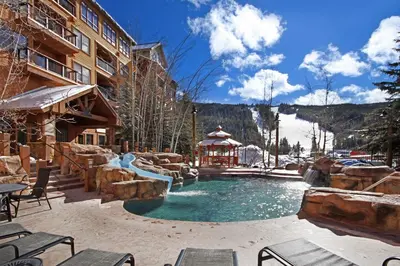 a resort pool with a waterfall and a slide at 8858 The Springs Condo in Keystone