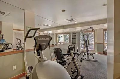 a gym with several treadmills and elliptical machines at 8858 The Springs Condo in Keystone