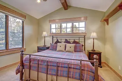 a bedroom with a bed and two windows at 170 Elk Circle Condo in Keystone