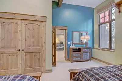 a bedroom with a bed and a desk and a mirror at 170 Elk Circle Condo in Keystone