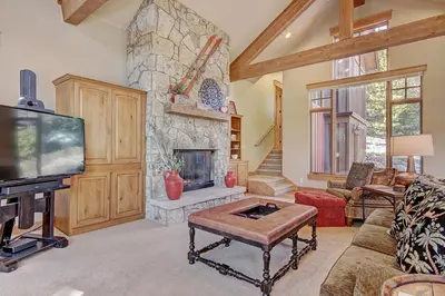 a living room with a tv and a stone fireplace at 170 Elk Circle Condo in Keystone