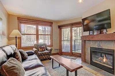 a living room with a fireplace and a flat screen tv at 8824 The Springs Condo in Keystone