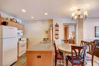 a kitchen and dining room with a table and chairs at 8824 The Springs Condo in Keystone