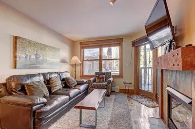 a living room with a leather couch and a tv at 8824 The Springs Condo in Keystone