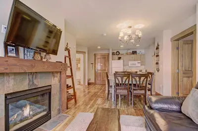 a living room with a fireplace and a dining room at 8824 The Springs Condo in Keystone