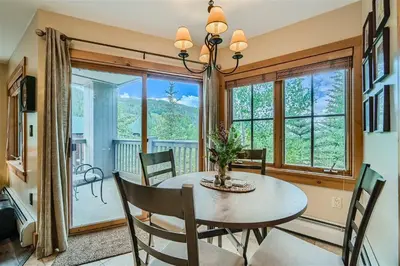 a dining room with a table and chairs and a large window at 8594 Expedition Station Condo in Keystone