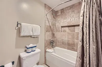 a bathroom with a shower and a toilet and a tub at 8594 Expedition Station Condo in Keystone
