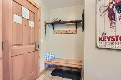 a hallway with a wooden door and a bench at 8594 Expedition Station Condo in Keystone