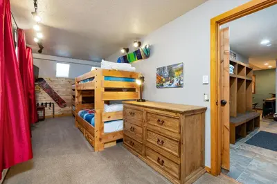 a bedroom with a bunk bed and a wooden dresser at 2054 The Pines Condo in Keystone