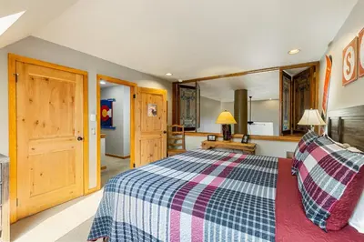 a bedroom with a bed with a checkered blanket at 2054 The Pines Condo in Keystone