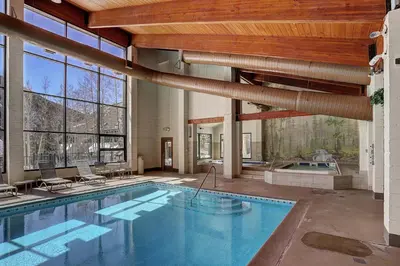a large swimming pool in a building with a large window at 2054 The Pines Condo in Keystone