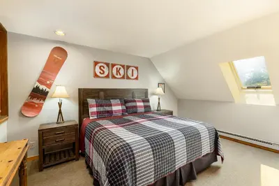 a bedroom with a bed and a snowboard on the wall at 2054 The Pines Condo in Keystone