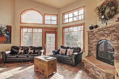 a living room with leather couches and a stone fireplace at 18 Autumn Brook Condo in Keystone