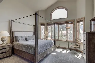 a bedroom with a canopy bed and a window at 18 Autumn Brook Condo in Keystone