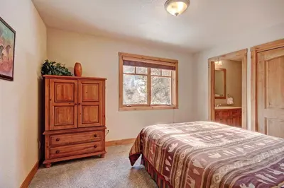 a bedroom with a bed and a dresser and a window at 18 Autumn Brook Condo in Keystone