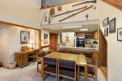 a kitchen and dining room with a wooden table and chairs at 2130 Pines Condo in Keystone