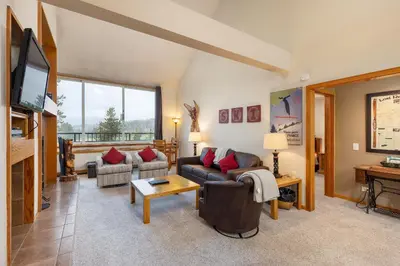 a living room with couches and a flat screen tv at 2130 Pines Condo in Keystone