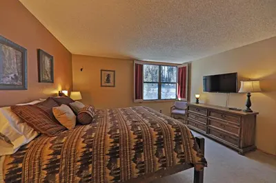 a bedroom with a bed and a flat screen tv at A11 Snowblaze Athletic Club Condo in Winter Park
