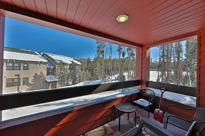 a balcony with a view of the snow covered trees at A11 Snowblaze Athletic Club Condo in Winter Park