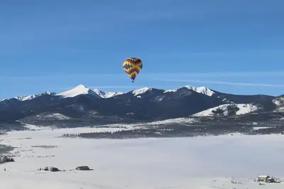 a hot air balloon flying over a snow covered mountain at A11 Snowblaze Athletic Club Condo in Winter Park