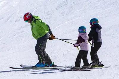 a group of three people skiing down a snow covered slope at A11 Snowblaze Athletic Club Condo in Winter Park