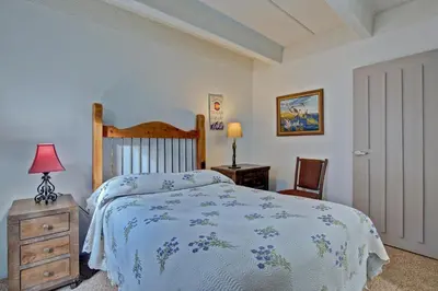 a bedroom with a bed and a dresser and a chair at Ten Mile Island 119C Condo in Frisco