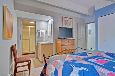 a bedroom with a bed and a flat screen tv at Ten Mile Island 119C Condo in Frisco
