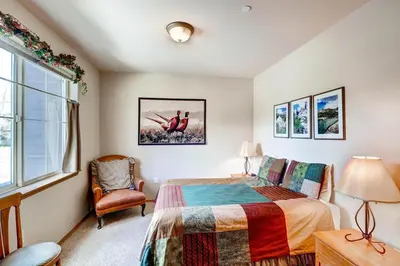 a bedroom with a bed and a chair and a window at Tarn Landing C-5 Condo in Frisco
