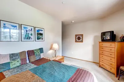 a bedroom with a bed and a tv and a dresser at Tarn Landing C-5 Condo in Frisco