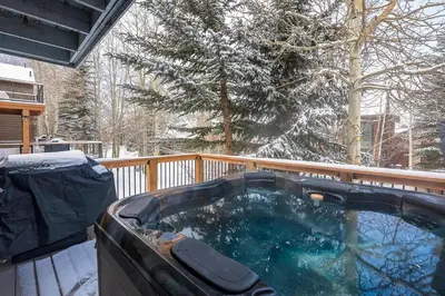 a hot tub on a deck in the snow at Mountainside 673 Home in Frisco