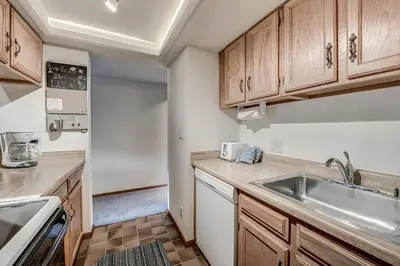a kitchen with wooden cabinets and a sink at Mountainside 229E Condo in Frisco
