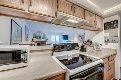 a kitchen with white appliances and wooden cabinets at Mountainside 229E Condo in Frisco