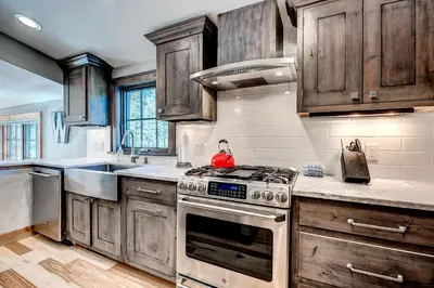 a kitchen with wooden cabinets and a stove top oven at Frisco Street Home in Frisco