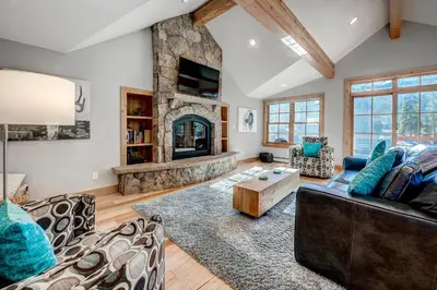 a living room with a large stone fireplace at Frisco Street Home in Frisco