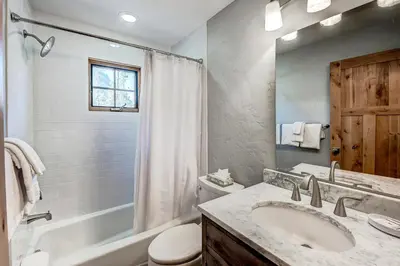 a bathroom with a sink and a tub and a toilet at Frisco Street Home in Frisco