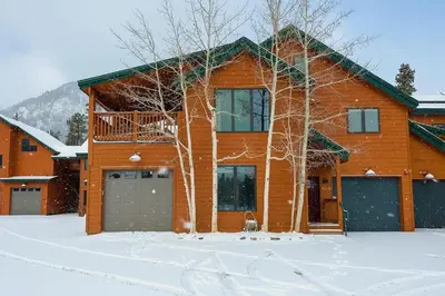 a house with a dog in front of it in the snow at Frisco River Townhomes #D in Frisco