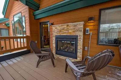 a porch with two chairs and a fireplace on a house at Frisco River Townhomes #D in Frisco