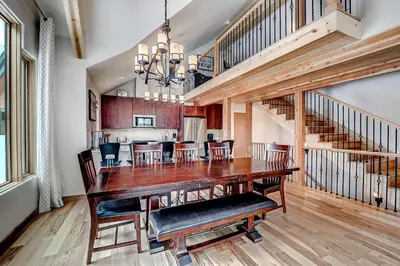 a dining room and kitchen with a wooden table and chairs at Frisco River Townhomes #D in Frisco