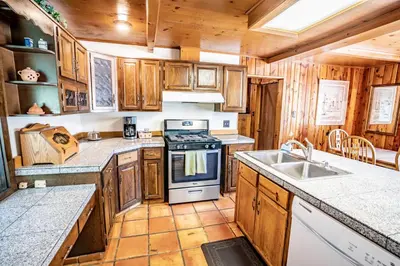a kitchen with wooden cabinets and a stove top oven at Colorado Bear Creek Cabins in Evergreen