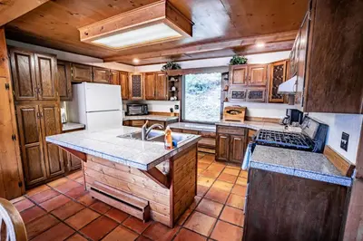 a kitchen with wooden cabinets and a counter top at Colorado Bear Creek Cabins in Evergreen